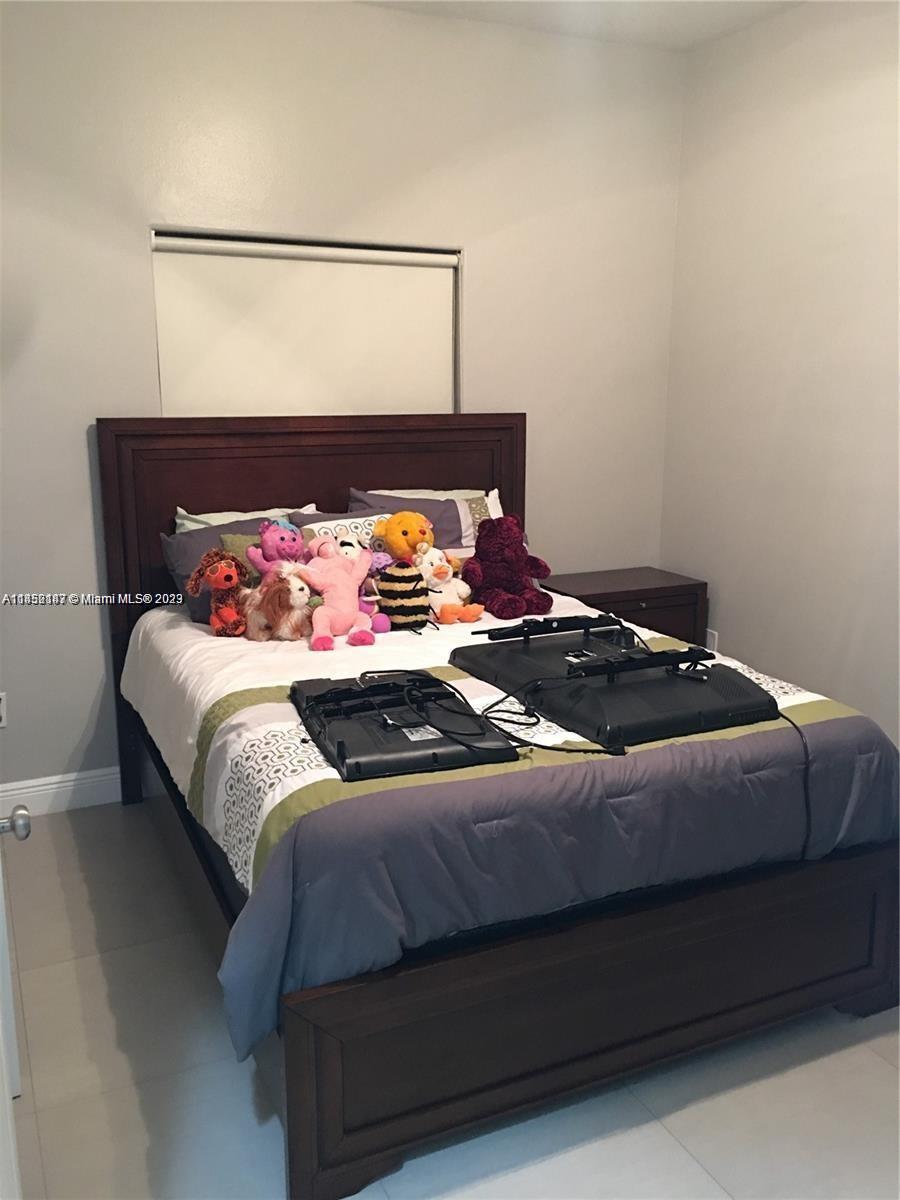 16124 Southwest 55th Terrace Miami, FL 33185 - Photo 19 of 23 a bedroom with a bed and dresser
