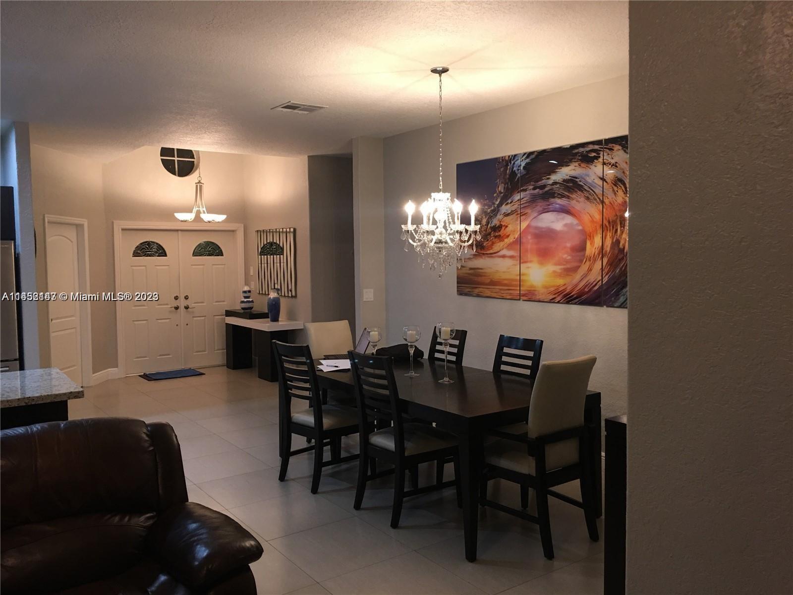 16124 Southwest 55th Terrace Miami, FL 33185 - Photo 6 of 23 a dining room with furniture and chandelier