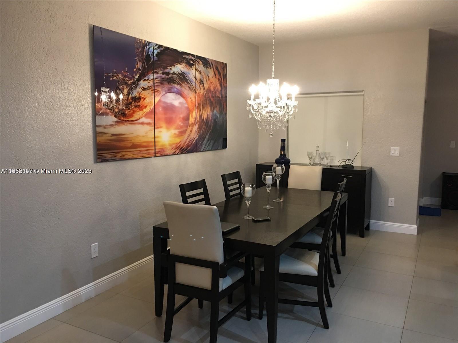 16124 Southwest 55th Terrace Miami, FL 33185 - Photo 7 of 23 a view of a dining room with furniture and chandelier