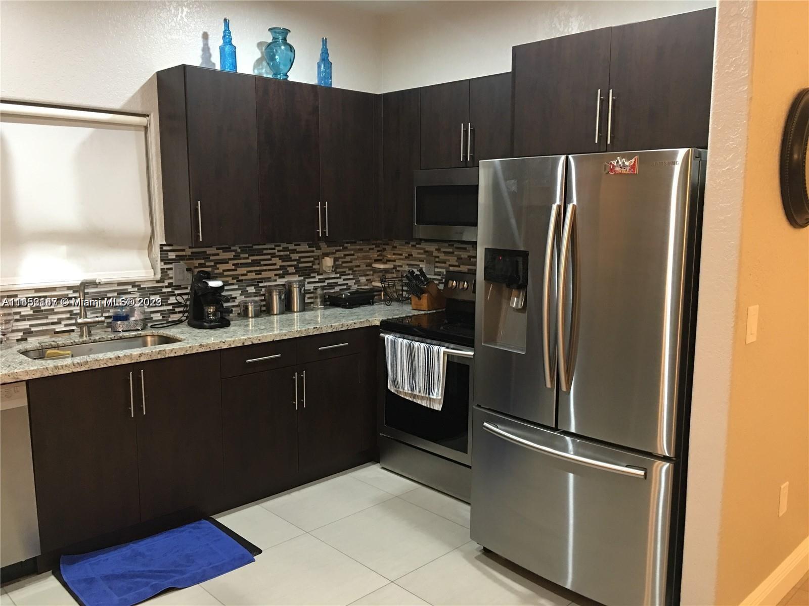 16124 Southwest 55th Terrace Miami, FL 33185 - Photo 8 of 23 a kitchen with stainless steel appliances granite countertop a refrigerator and a sink