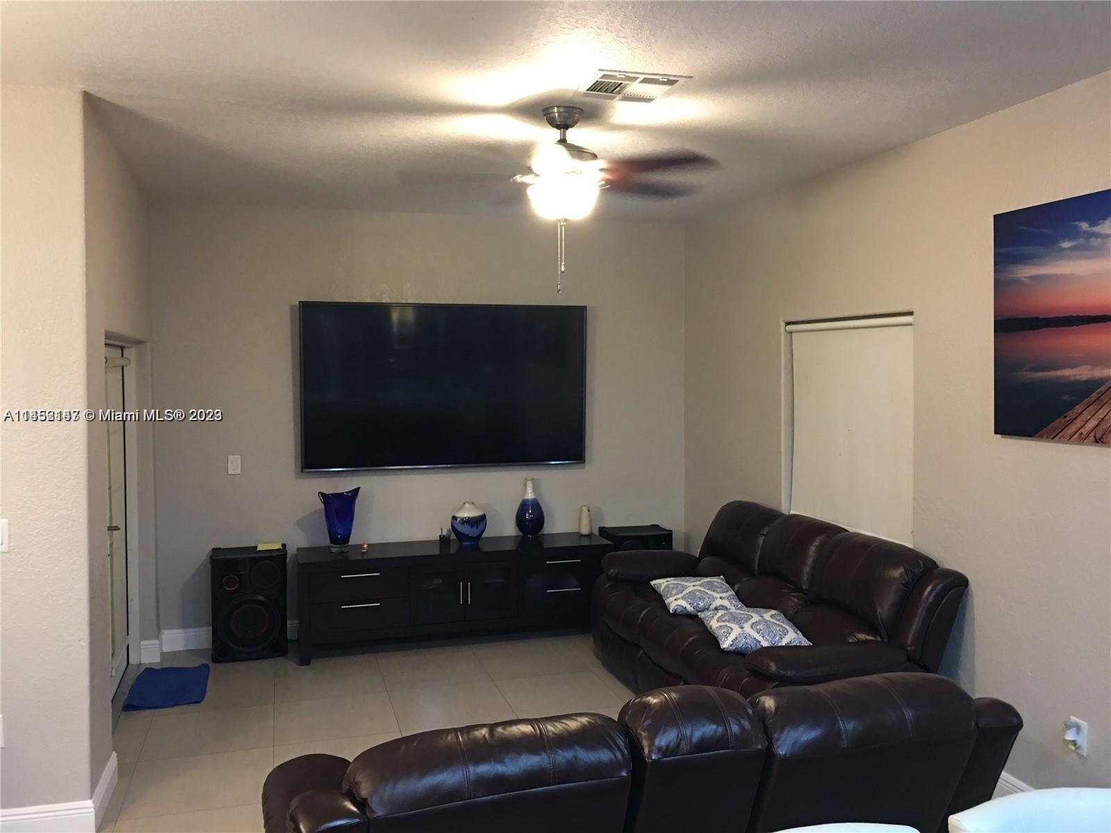 16124 Southwest 55th Terrace Miami, FL 33185 - Photo 10 of 23 a living room with furniture and a flat screen tv