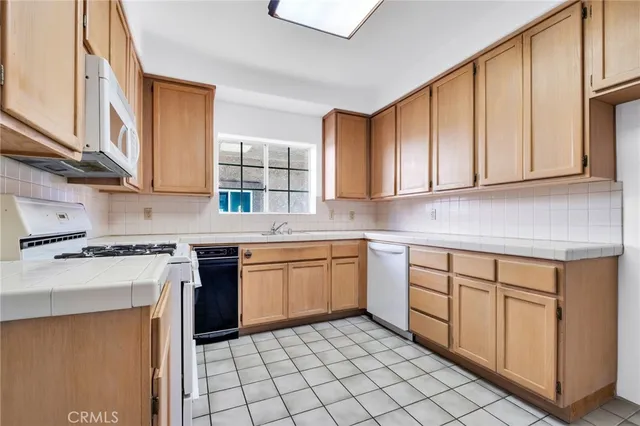 a view of an empty room with a window and a kitchen