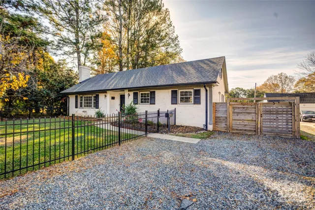 a view of a house with a big yard and a large tree