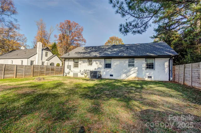 a view of a house with a backyard and a tree