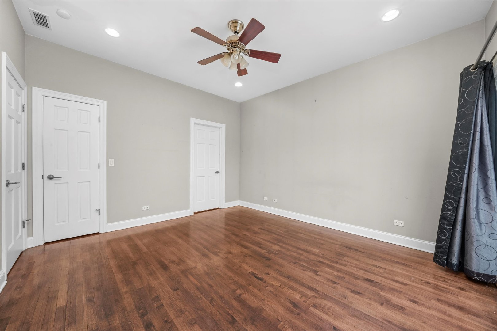 2430 West Iowa Street, Unit 3 Chicago, IL 60622 - Photo 12 of 21 an empty room with wooden floor and a ceiling fan