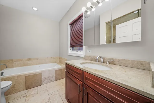 a bathroom with a sink a bathtub and a mirror