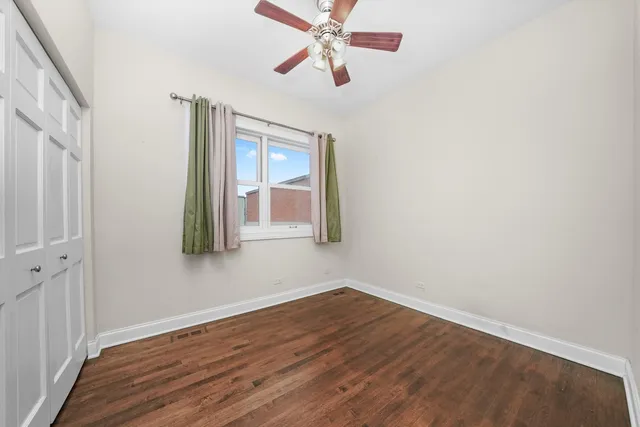 a view of a room with wooden floor and fan
