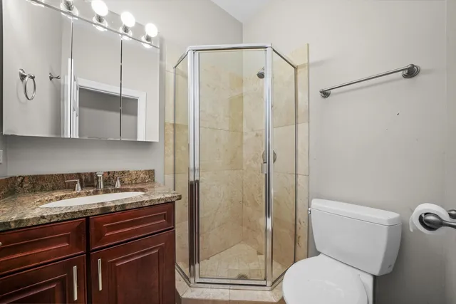 a bathroom with a granite countertop sink toilet and shower