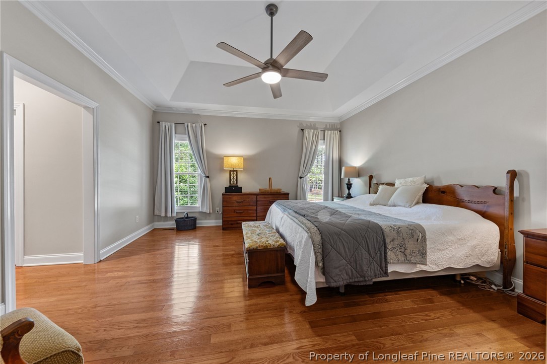 30180 East Lake Road Wagram, NC 28396 - Photo 21 of 42 a spacious bedroom with a large bed and a chandelier