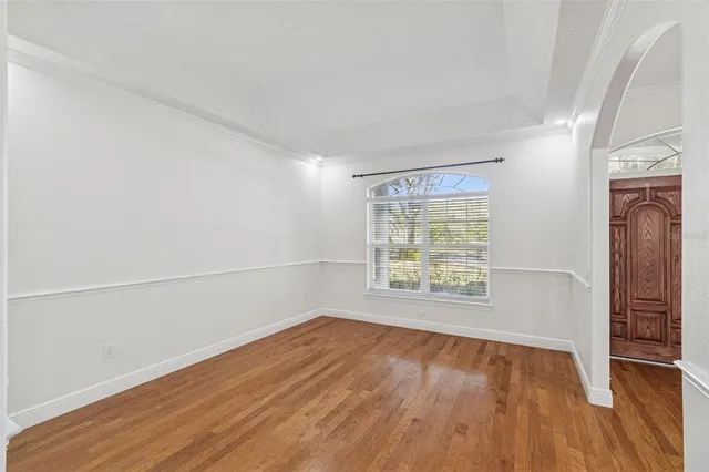 a view of a room with wooden floor and ceiling fan
