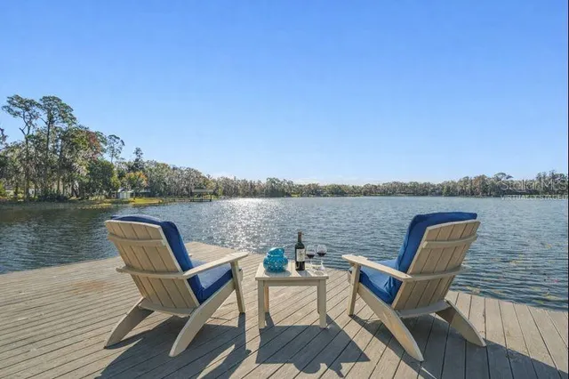 a view of a lake with table and chairs