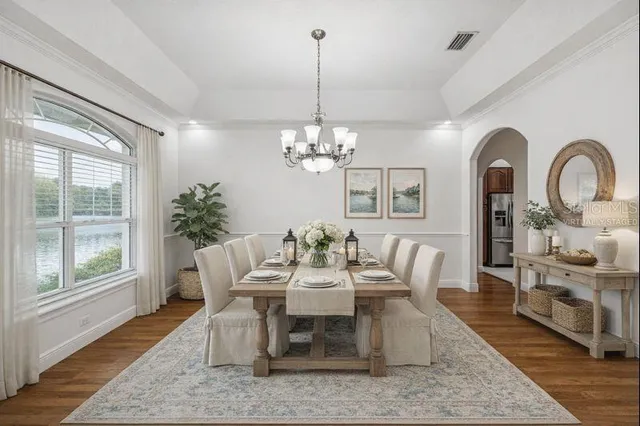 a dining room with furniture a chandelier and wooden floor
