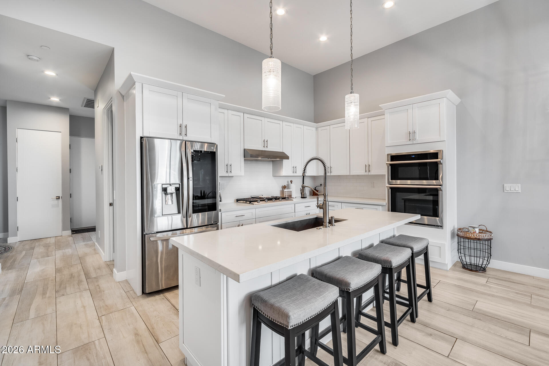 a kitchen with stainless steel appliances a refrigerator a sink a stove a dining table and chairs