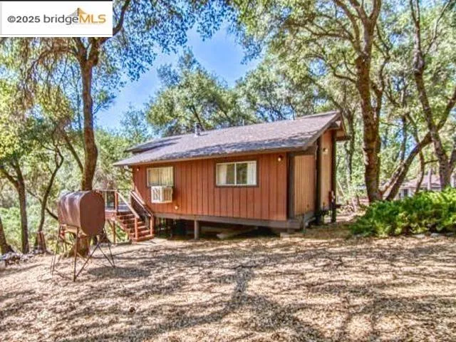 a view of a house with a yard and sitting area