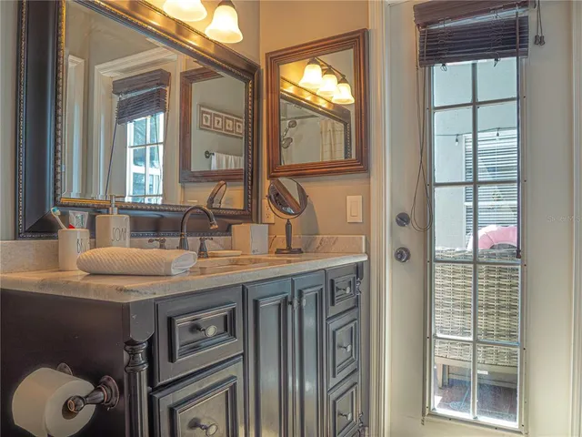 a bathroom with a granite countertop sink and a mirror