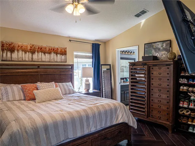 a bedroom with a bed and a flat tv screen on dresser
