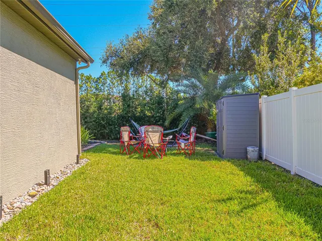 a view of a backyard with table and chairs and a small yard