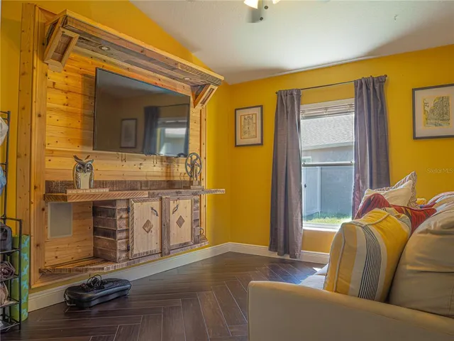 a living room with stainless steel appliances furniture and a kitchen view