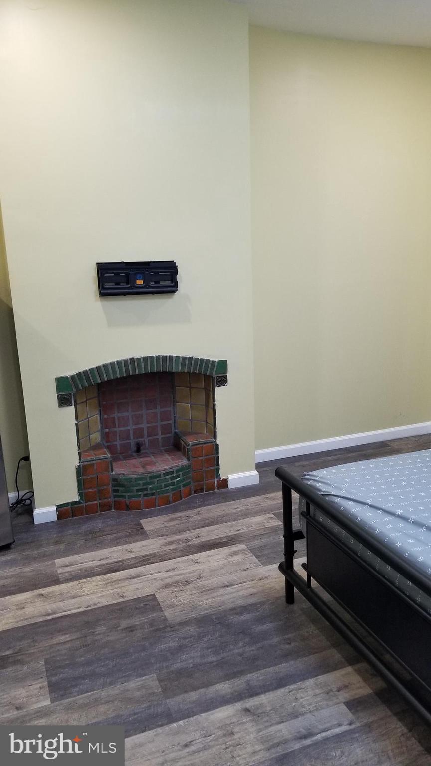 1120 Locust Street, Unit 301 Philadelphia, PA 19107 - Photo 2 of 9 a room with wooden floor and a fireplace