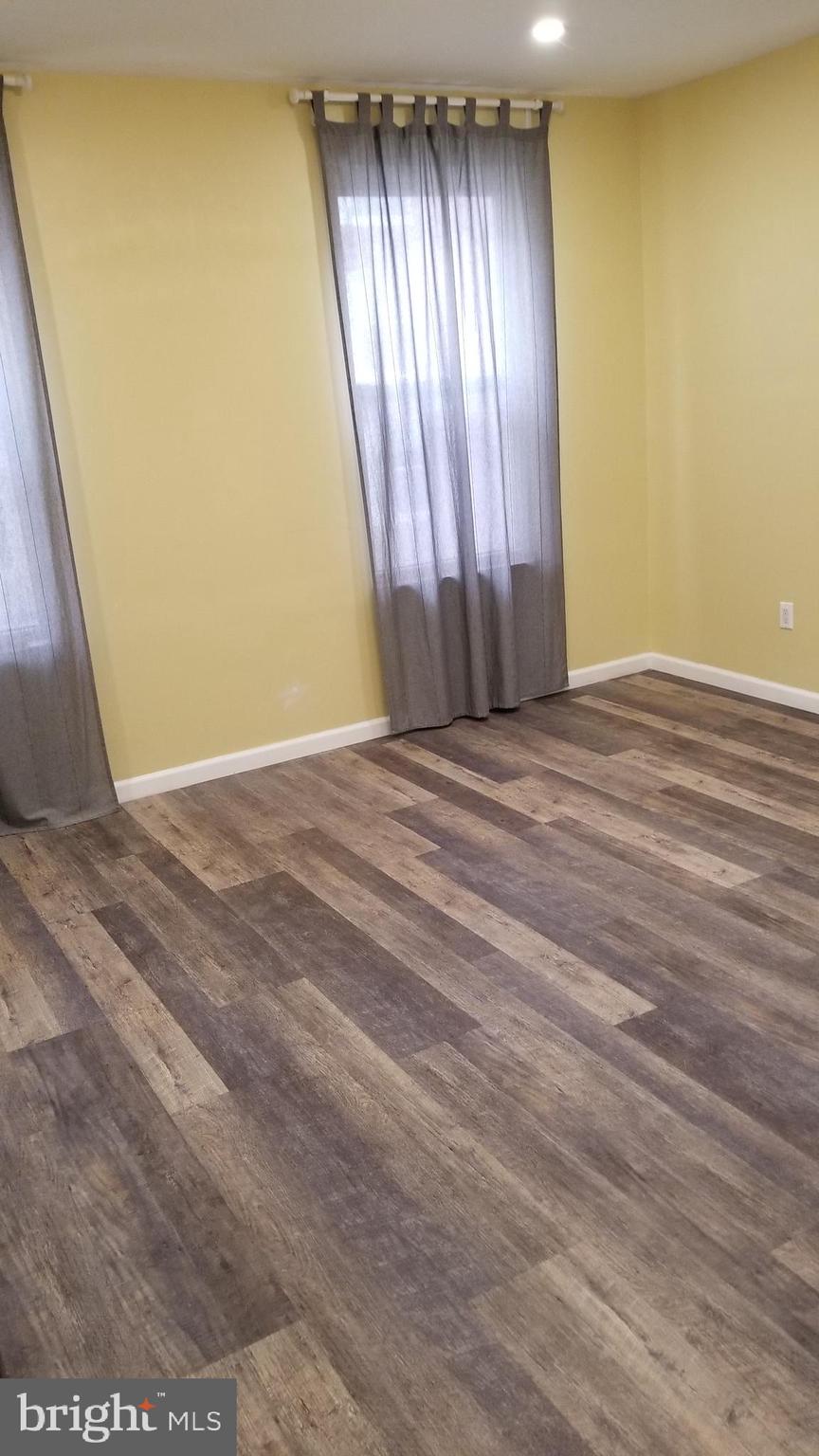 1120 Locust Street, Unit 301 Philadelphia, PA 19107 - Photo 3 of 9 an empty room with wooden floor and windows