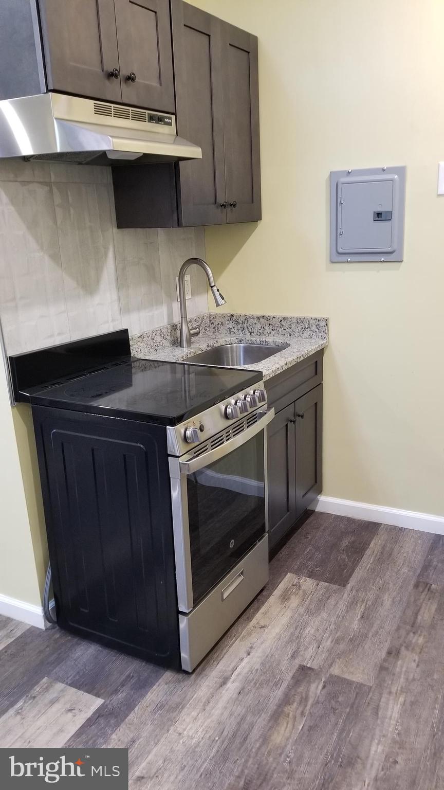 1120 Locust Street, Unit 301 Philadelphia, PA 19107 - Photo 4 of 9 a kitchen with stainless steel appliances a stove and a microwave