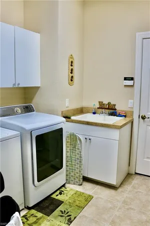a utility room with stainless steel appliances kitchen island a stove a sink and a microwave