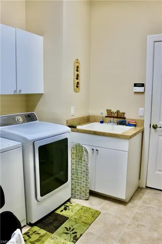 a utility room with stainless steel appliances kitchen island a stove a sink and a microwave