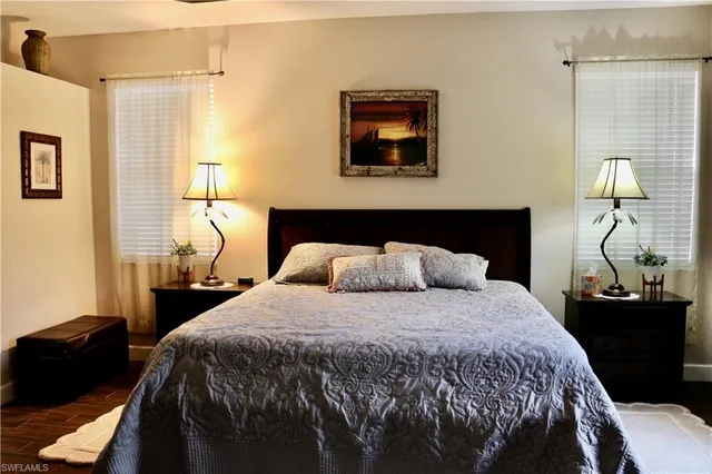 a bedroom with a bed and a lamp next to a window