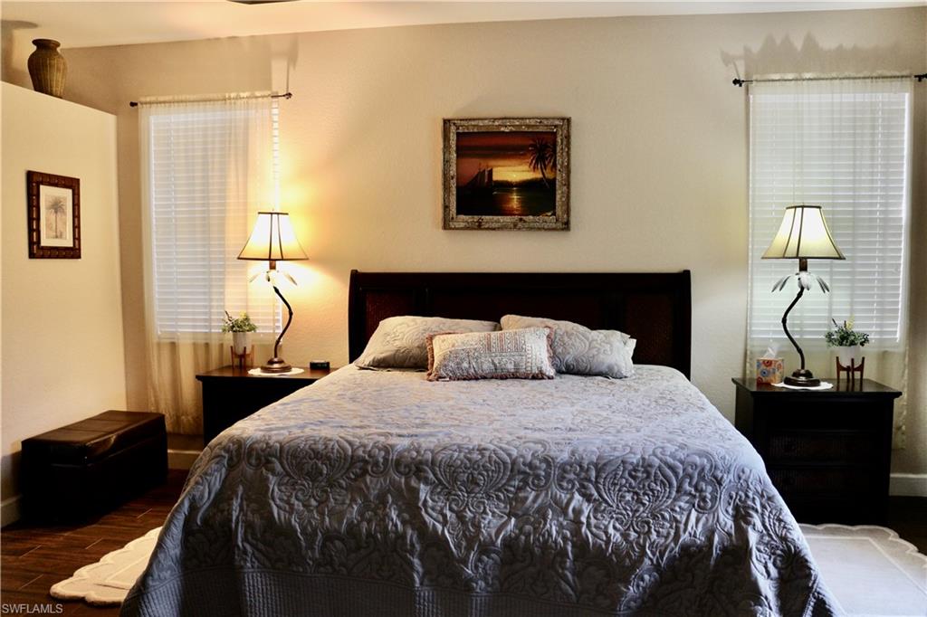 15474 Los Reyes Lane Naples, FL 34110 - Photo 12 of 36 a bedroom with a bed and a lamp next to a window