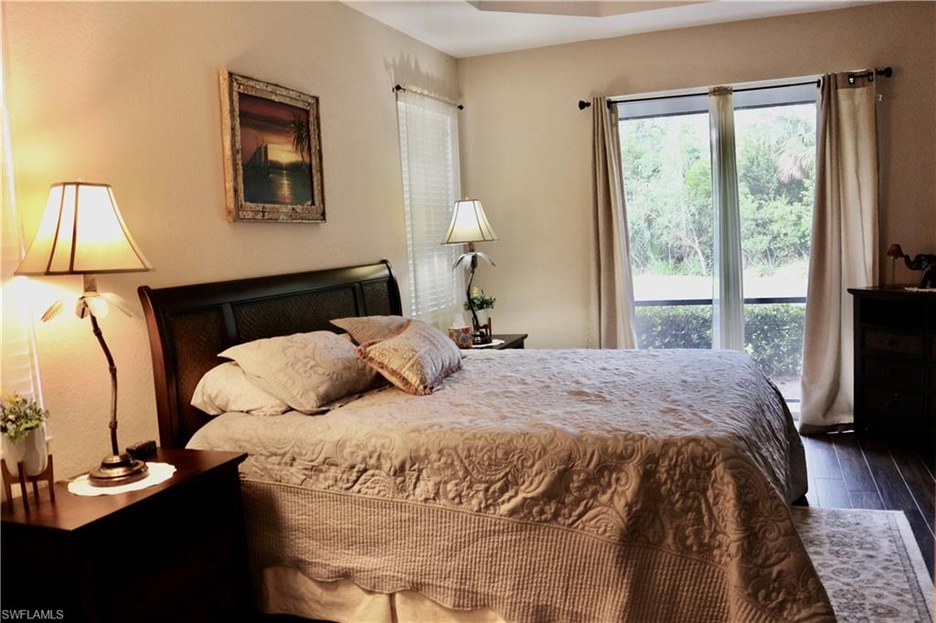 15474 Los Reyes Lane Naples, FL 34110 - Photo 13 of 36 a bedroom with a bed and a lamp next to a window