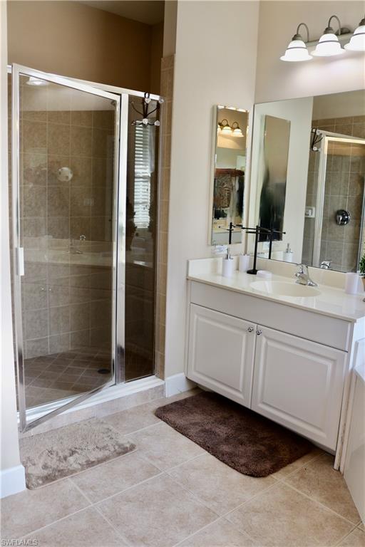 15474 Los Reyes Lane Naples, FL 34110 - Photo 15 of 36 a bathroom with a shower sink and mirror