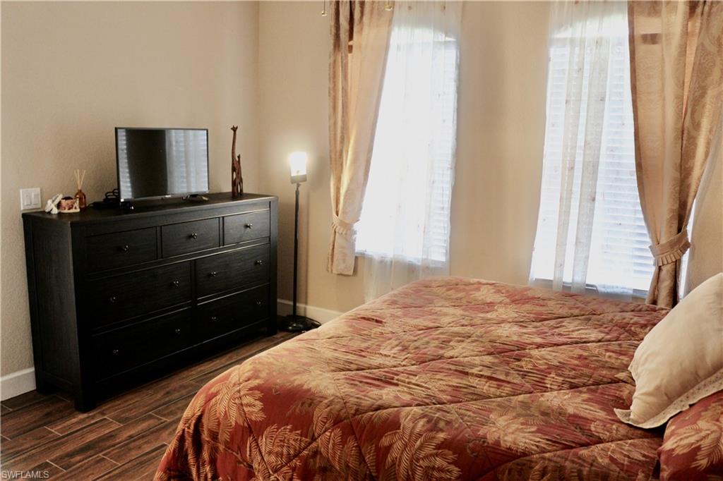 15474 Los Reyes Lane Naples, FL 34110 - Photo 18 of 36 a bedroom with a bed and a mirror