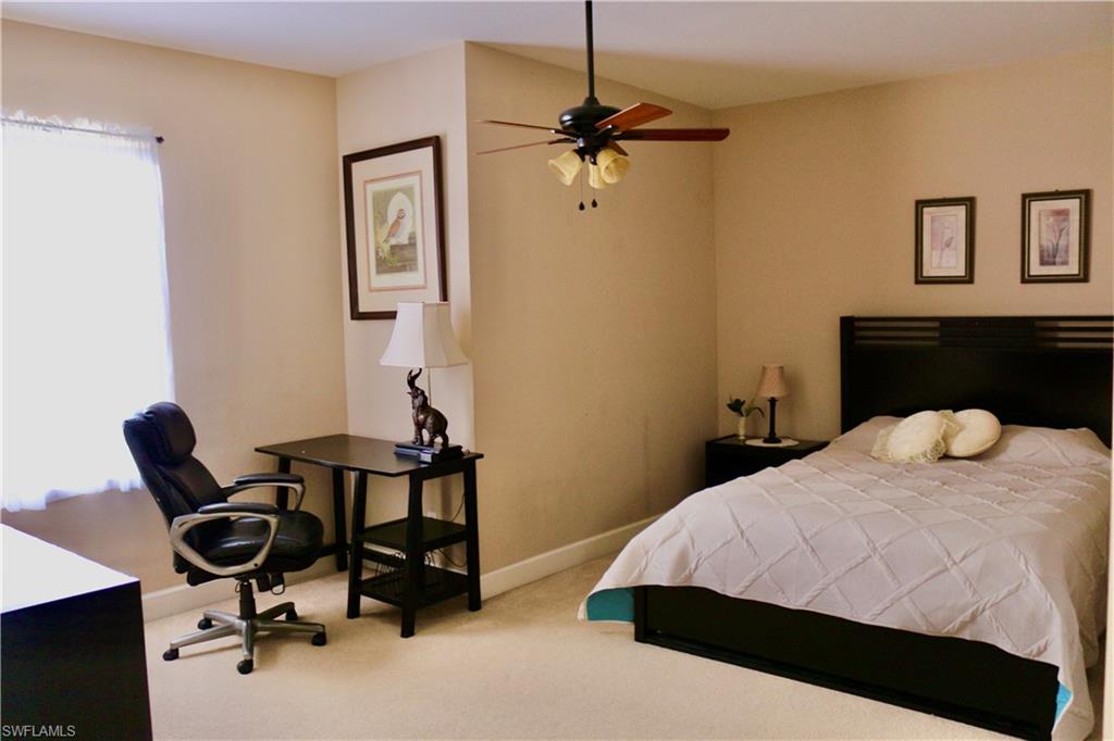 15474 Los Reyes Lane Naples, FL 34110 - Photo 22 of 36 a bedroom with a bed and a chair