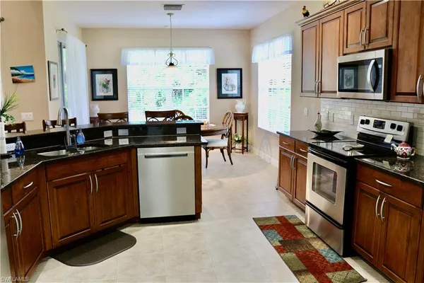 a kitchen with stainless steel appliances granite countertop a stove a sink and a microwave