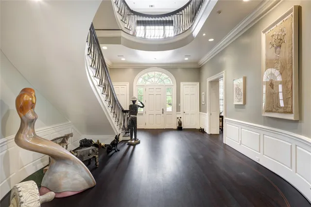 a view of a hallway with wooden floor windows and a chandelier