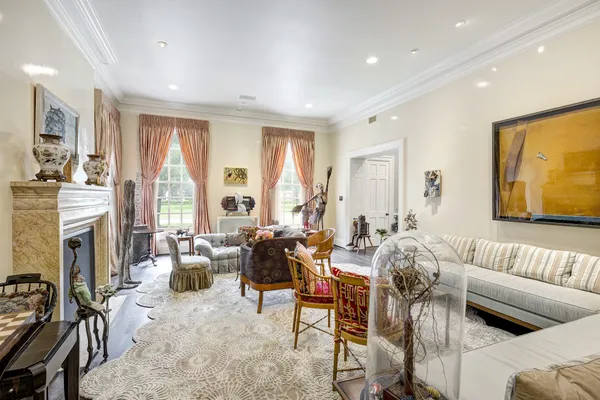 a living room with fireplace furniture and a large window