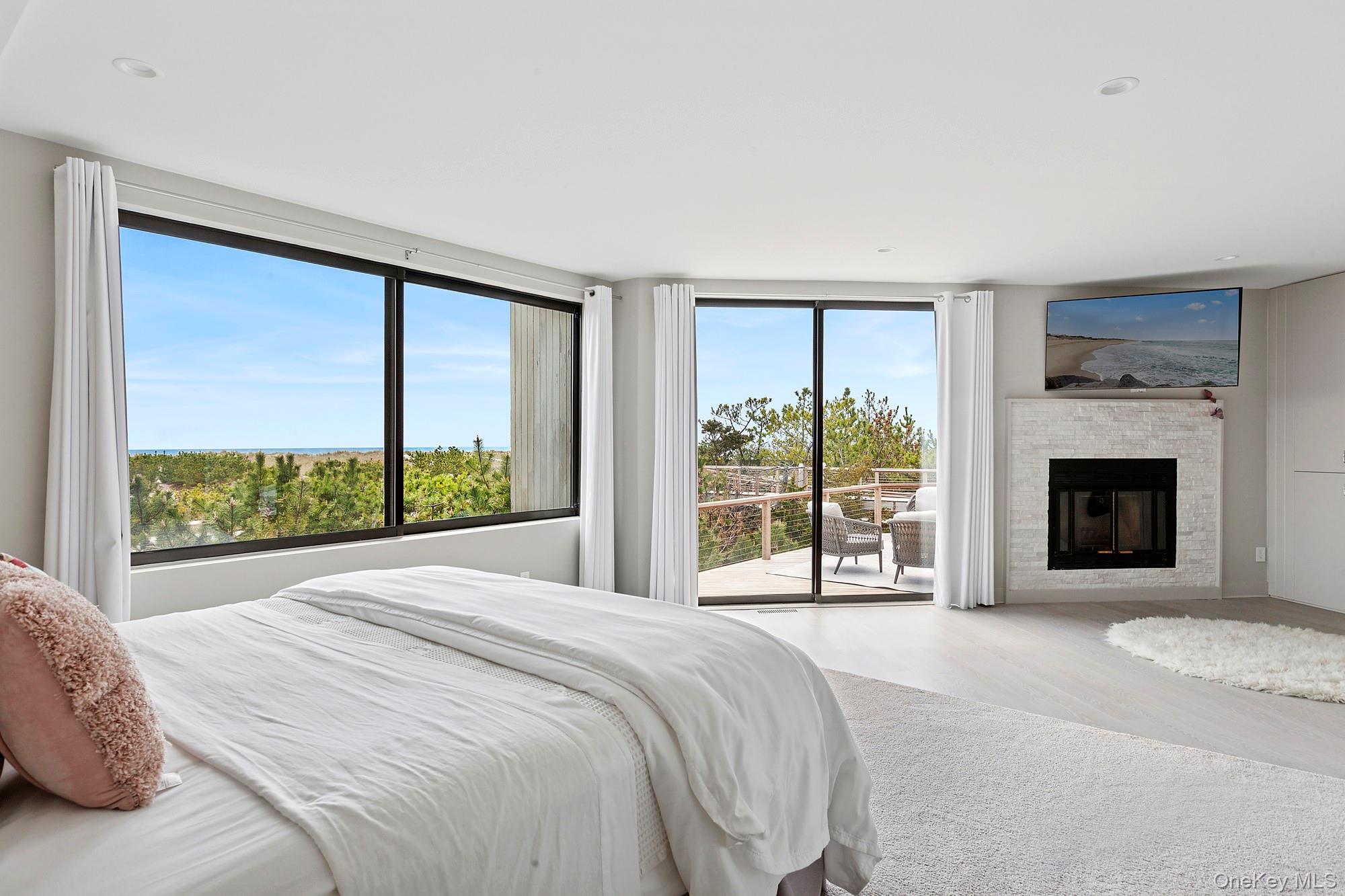 199 Dune Road Westhampton Beach, NY 11978 - Photo 11 of 38 a bed sitting in a spacious bedroom next to a window