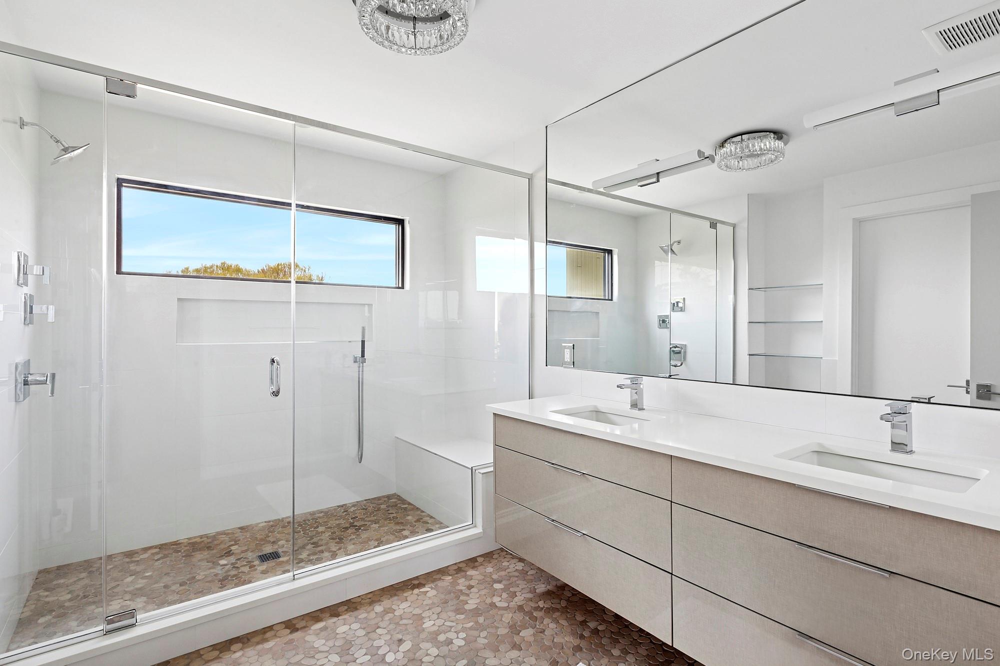 199 Dune Road Westhampton Beach, NY 11978 - Photo 12 of 38 a bathroom with a shower sink and mirror