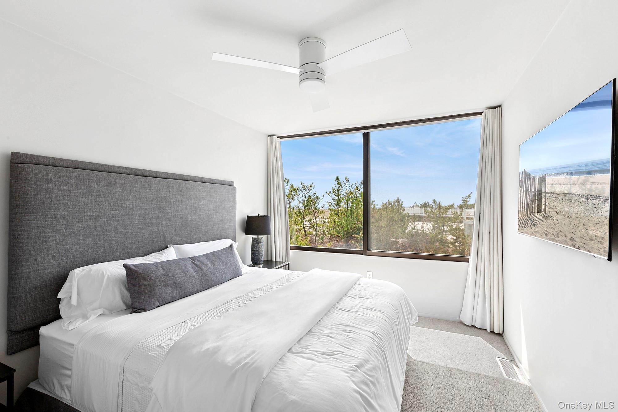 199 Dune Road Westhampton Beach, NY 11978 - Photo 17 of 38 a bedroom with a large bed and a window