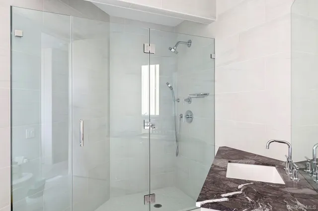 a bathroom with a granite countertop shower a sink and a mirror