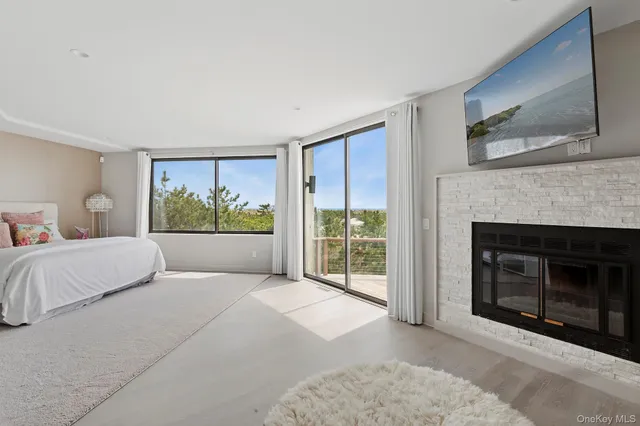 a bedroom with a balcony a bed and a fireplace