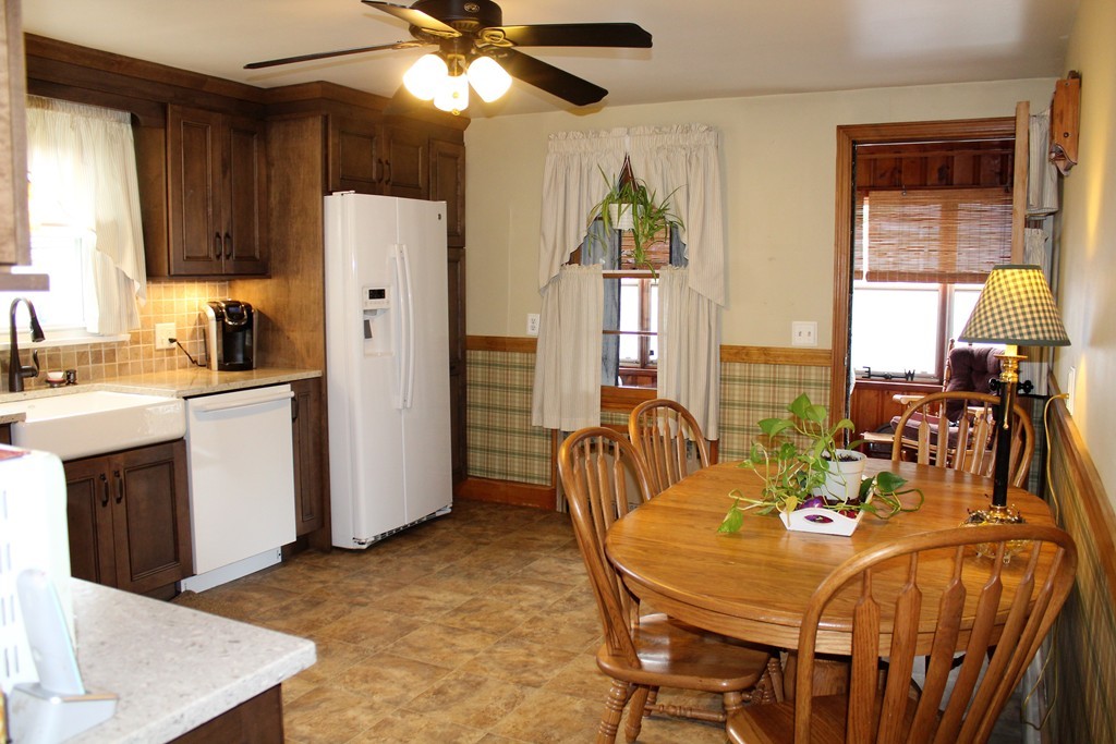 65 Primrose Street Springfield, MA 01151 - Photo 15 of 30 a dinning room with stainless steel appliances kitchen island granite countertop a table chairs and a refrigerator