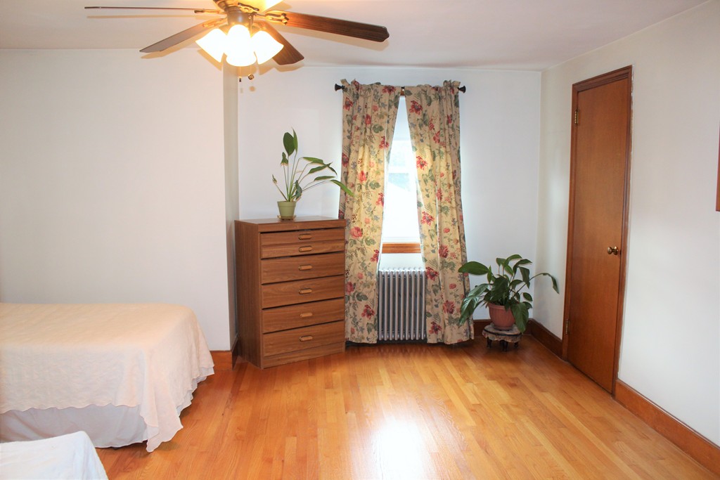 65 Primrose Street Springfield, MA 01151 - Photo 26 of 30 a bedroom with a bed and a chandelier