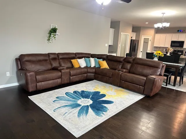 a living room with furniture and kitchen view with wooden floor