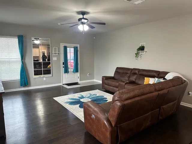 a living room with furniture and wooden floor