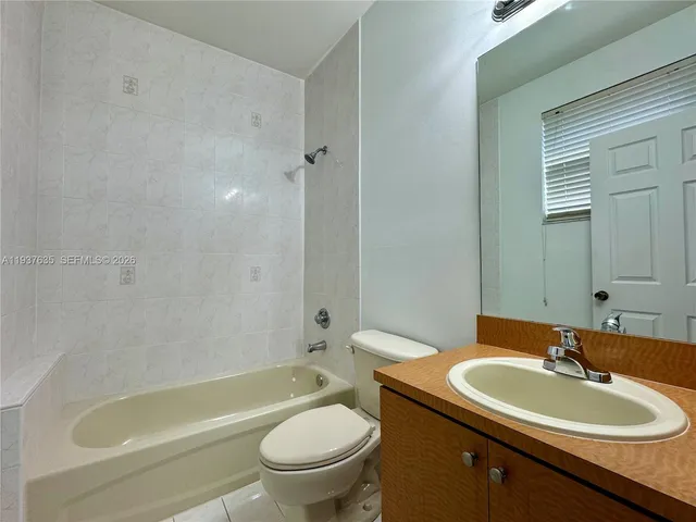 a bathroom with a sink toilet mirror and bathtub