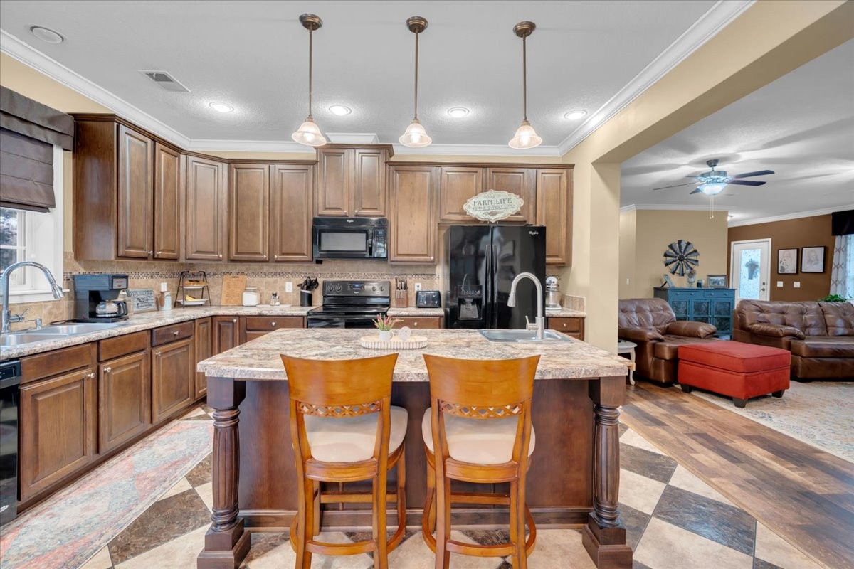 1798 Holly Grove Road Lewisburg, TN 37091 - Photo 16 of 55 a kitchen with stainless steel appliances kitchen island granite countertop a dining table chairs sink and white cabinets