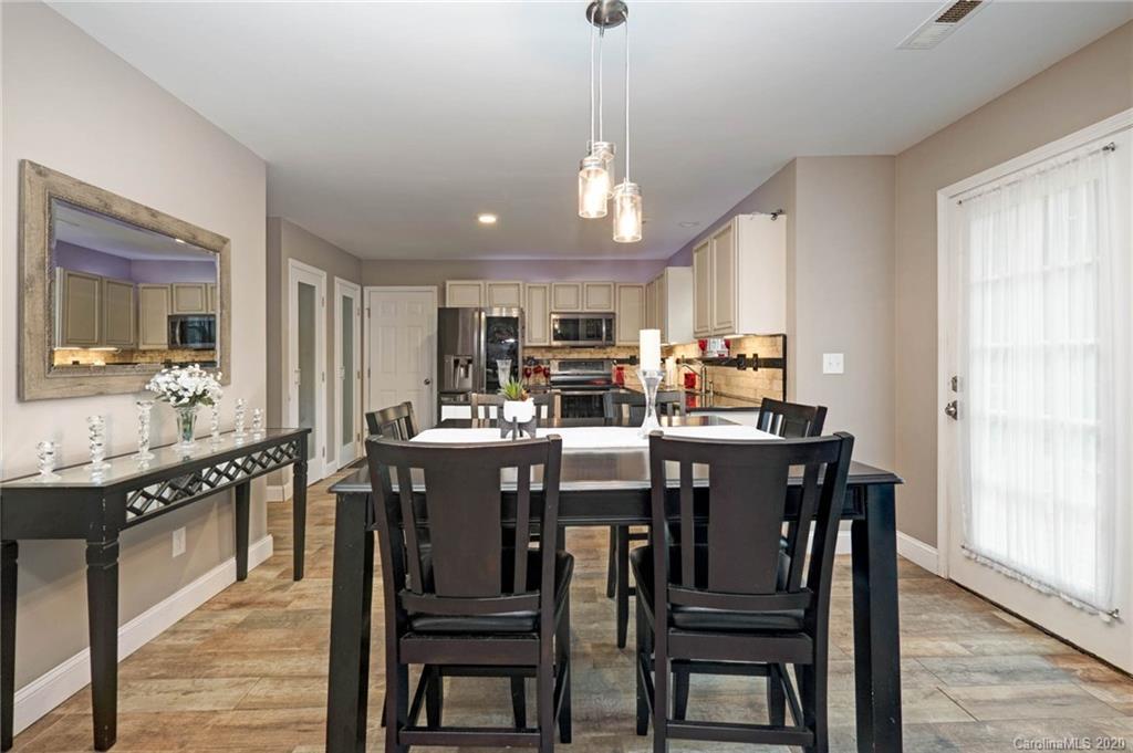 1433 Autumn Ridge Lane Fort Mill, SC 29708 - Photo 11 of 38 a kitchen with stainless steel appliances granite countertop a kitchen island a stove a table and chairs in it