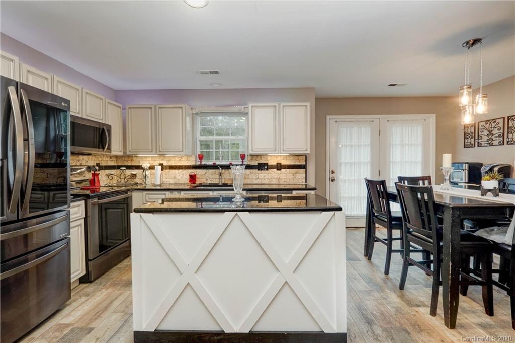 1433 Autumn Ridge Lane Fort Mill, SC 29708 - Photo 14 of 38 a kitchen with stainless steel appliances a table and chairs in it