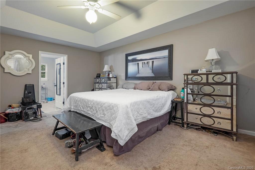 1433 Autumn Ridge Lane Fort Mill, SC 29708 - Photo 22 of 38 a bedroom with a bed a chandelier and a dresser